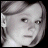 Pixelated grayscale image of a person's face with short hair, neutral expression, and visible eyes nose mouth against dark background.