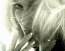 A static close-up of a person's face with long light brown hair, showing subtle color variations