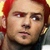 Pixelated close-up of a person with red hair, light skin, and dark eyes, wearing a dark top against a blurred background.