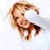 Pixelated image of a person with light brown hair lying on their back, arms raised, against a light background.