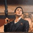 Pixelated image of a person in dark clothing holding an object, with blurred background elements.