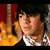 A person with dark hair appears in three distinct poses: standing before a guitar, resting their head on a hand, and wearing a cap.