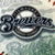 Pixelated image of a metallic object with circular elements on the left, and yellow text reading "Milwaukee Brewers OWN!" on a dark blue background.