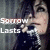 Pixelated image of a person with light skin and dark hair holding a microphone, with text reading 'Sorry' and 'Lasts' overlaid on a dark background.