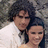 Two people in white clothing pose closely together against a textured stone background, with subtle expression changes across frames.