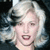 Static pixelated image of a person with light-colored hair and visible facial features against dark background.