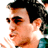 Pixelated static image of a person's face in profile with dark hair, sunglasses, and visible facial features including nose, mouth, and ear.
