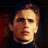 Pixelated static image of a person's face with warm lighting and dark background, rendered in low-resolution 256x256 pixels.