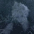 Pixelated static image of a light gray figure with indistinct features against dark blue background, no visible text or distinct objects.