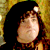 Pixelated static image of a character with dark hair and light skin against a yellow background, likely from Santa Clause 2 movie content.