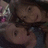 Pixelated static image of two figures in close proximity, one with light-colored hair and pink accents on the left, both rendered in muted brown tones.