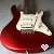 Red electric guitar with white pickguard and black heart symbol at bottom right corner.