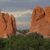 Pixelated landscape showing two large orange rock formations against a cloudy sky with green vegetation below.
