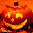 Pixelated orange pumpkin with carved face, glowing eyes and mouth on dark background, text fragments visible around it.