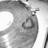A grayscale icon featuring a stylized heart shape with layered outlines, set against a pixelated background of light and dark gray tones.