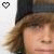 Pixelated image of a person with light brown hair and dark cap, featuring two heart icons in top corners.