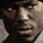 A pixelated image of a man's face above a black background with yellow chevron arrows and white text reading "MACHINE GUN JOE" and "DEATH RACE".