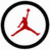 Red silhouette of a basketball player jumping inside black circular border on white background.