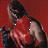 Pixelated figure in red and black attire against a solid red background, with visible white accents on the chest.