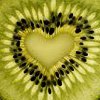 A heart-shaped arrangement of black seeds forms a border around a light yellow center on a golden-yellow background with radiating lines.