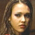 Static pixelated image of a person with light skin tone, dark eyes, and long brown hair against a muted background.