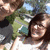 Two people in a pixelated outdoor scene with green foliage and blue sky, one person in a white top and dark hair, the other in a dark top with light hair.
