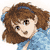 Pixelated cartoon-style image of a person with brown curly hair and a blue top, showing a slightly open mouth and one visible eye.