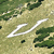 Static pixelated image showing a white curved line on a green and beige pixelated background with scattered dark green patches.