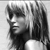 Black-and-white pixelated image of a person's face in profile view with visible hair and neck, rendered in low-resolution grayscale with high contrast between light and dark areas.