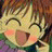 A pixelated anime-style character with closed eyes and a wide smile on the left, next to black background text reading "Anime IM" above smaller cursive "cOm" on the right.