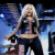 Animated sequence of a woman with long blonde hair performing on stage, wearing dark clothing and holding a microphone.