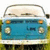 Pixelated blue and white vehicle with rounded headlights, orange side markers, and a curved roofline against a light background.