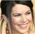A static pixelated image shows a person with light skin, dark hair, and a smiling expression, cropped to show the head and shoulders against a blurred background.