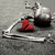 A silver tray holds a red heart-shaped object and a dark liquid in a glass bottle against a gray background.