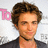 Pixelated image of a person with short brown hair wearing a dark jacket over a light shirt, with a pink 'To' text fragment on the left side.