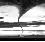 Black-and-white pixelated image showing a tornado-like vortex over water with horizontal bands of varying grayscale tones.