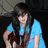 A static image shows a person in a blue shirt holding an instrument, with overlaid text fragments on black background.