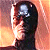Pixelated profile view of a person with dark hair wearing a dark jacket against a warm-toned gradient background.