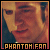 Pixelated image of a person with light skin and dark hair, wearing a dark blue garment, against warm-toned background with text "PHANTOM FAN" at bottom.