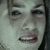 Static pixelated image of a person's face with visible eyes, nose, mouth, and dark hair against a light background.