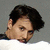 A person with dark hair and a white shirt appears in a of four showing slight head position changes against a gray background