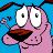 Pixelated cartoon character with pink skin, large white eyes, and a wide open mouth holding an orange object against a solid blue background.