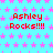 A static digital image with a light blue background covered in pink star patterns, displaying repeated red text "Ashley Rocks!!!!" in a pixelated font.