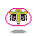 Pixelated circular icon with pink border, yellow cross on gray base, black and pink facial features, and small shadow below.