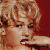 Static pixelated image of a woman's face with blonde hair and red lipstick against a solid red background, rendered in low-resolution 256x256 pixels.