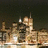 Pixelated static image of a cityscape with multiple buildings under dark sky, featuring varied architectural styles and light-colored facades.