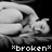 *broken* text appears below a grayscale pixelated figure lying on its side against black background.