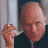 Static 48x48 pixel icon showing a close-up of a bald man in dark clothing holding a white cylindrical object against a light background.