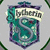 Pixelated shield-shaped icon with teal and purple hues, featuring a stylized 'R' emblem on the left side and partial text reading 'Falkor' across the top.