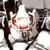 Pixelated static image of a character with brown hair and light skin, holding a glowing white object against a gray background.